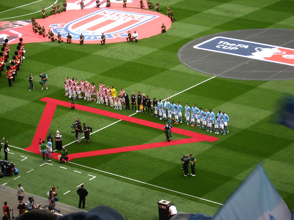 The two teams lined up on the Wembley pitch before kick-off, Stoke in red and white on the left, Manchester City in blue on the right