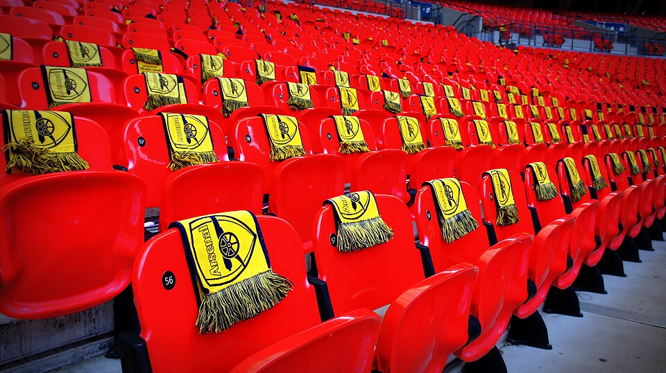 Yellow Arsenal scarves laid out across rows of red Wembley seats