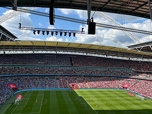 A view across the Wembley pitch during a match, with the stands full