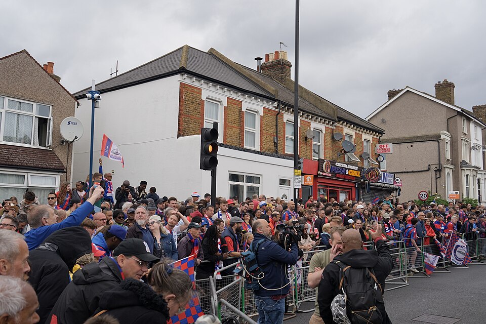 An open-top bus carrying Crystal Palace players through crowded south London streets